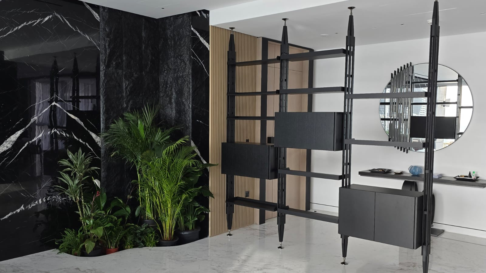 Modern interior design with black marble walls, plants, and a stylish shelf.